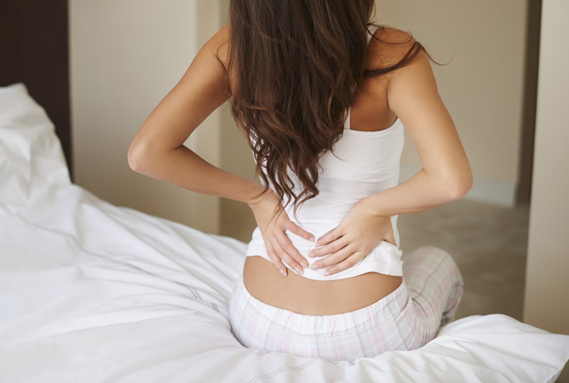 Mujer joven con dolor en la parte baja de la espalda que puede ser lumbalgia